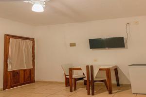 塞古罗港Pousada Migo的用餐室配有桌椅和墙上的电视