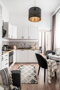 黑杜纳耶茨Apartament Biała Perła的厨房配有白色橱柜和桌椅