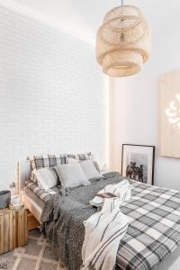 黑杜纳耶茨Apartament Biała Perła的一间卧室配有一张大床和一张带格子毯子的卧室