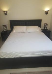 赫尔格达Chalet at Stella Makadi Beach的一张配有白色床单和枕头的大床