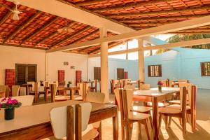 塞古罗港Pousada Migo的一间带桌椅的用餐室和大窗户