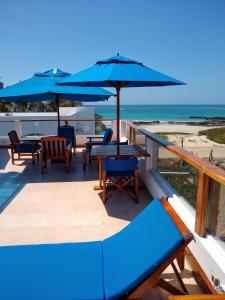 比亚米尔港德雷克住宿加早餐旅馆的海滩上带桌子和遮阳伞的甲板