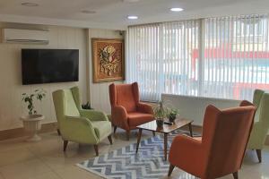 乔尔卢EViM HOTEL的一间设有椅子和平面电视的等候室