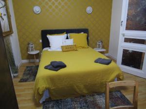 博韦奥涅杜提尔住宿加早餐旅馆的一间卧室配有黄色的床和2条毛巾