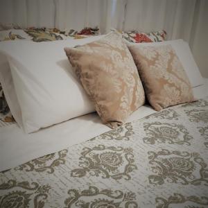 莫罗圣保罗Serena Morro的一张带白色床单和枕头的床