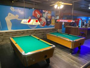 MinnedosaValley Motor Lodge的游戏室内两张带标志的台球桌