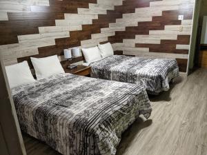 MinnedosaValley Motor Lodge的酒店客房带两张床和砖墙
