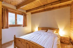 勒穆尚Chalet Val de l'Amblève的一间卧室,卧室内配有一张木床