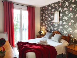 内尔哈阿扎哈拉旅馆的一间卧室配有一张带花卉壁纸的床