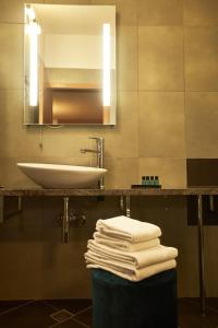 马里博尔维拉艾美酒店的浴室配有盥洗盆、镜子和毛巾
