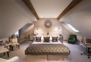 伊尔明顿The Howard Arms的一间卧室配有一张大床,墙上挂着一个时钟