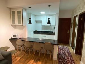 坎波斯杜若尔当Apartamento Campos do Jordao Home Green Home的一个带柜台和椅子的厨房