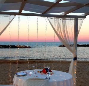 蒙特西尔瓦诺海滨长廊酒店的海滩上的白色桌子和帐篷