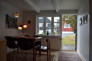 托尔斯港Cosy house in the heart of Tórshavn (Á Reyni)的一间带桌椅和窗户的用餐室