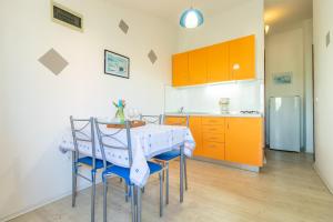 法扎纳Belvedere的厨房配有桌椅和橙色橱柜。