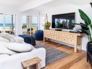 黄金海岸Absolute Beachfront Family Size Home的客厅配有白色沙发和大电视