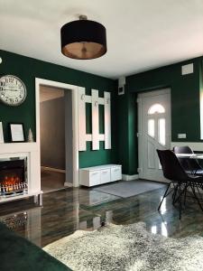 锡比乌VERACI Apartments的客厅设有绿色的墙壁和壁炉