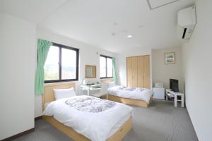 洞爷湖洞爷温泉华美传统日式旅馆的酒店客房设有两张床和窗户。