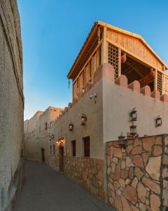 尼兹瓦Bait Al Aqr的一条在墙上建有建筑物的小巷