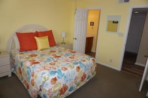 默特尔比奇Shores of Surfside I - 205 home的一间卧室配有一张带五颜六色棉被的床