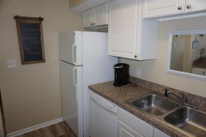 默特尔比奇Shores of Surfside I - 205 home的厨房配有水槽和白色冰箱