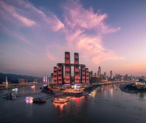重庆重庆来福士洲际酒店的一座大建筑,位于一条河流上,与城市相连