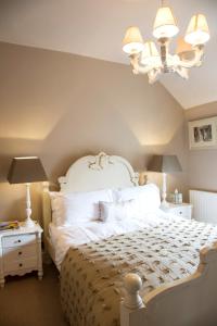 勒德洛萨尔威艾姆酒店的卧室配有一张白色大床和吊灯。