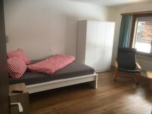 萨斯格伦德卡尔梅纳公寓的一间小卧室,配有一张床和一把椅子