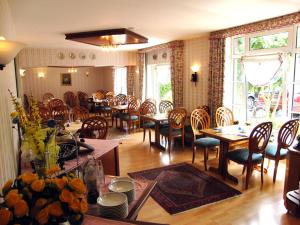FedderwardersielHotel Zur Fischerklause的用餐室设有木桌椅和用餐室