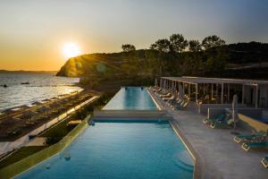伊里斯斯Mount Athos Resort的一个带游泳池和椅子的度假胜地和大海