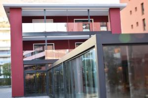 洛迦诺Hotel Bellavista Locarno的前面有玻璃窗户的红色建筑