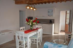 卡斯塔涅托卡尔杜奇Le Bozze "Casa Olivo"con piscina, WI-FI的厨房配有一张桌子,上面放着花瓶