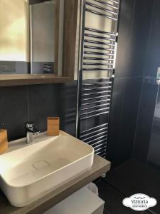 马代西莫Vittoria Casa Vacanza的浴室配有白色水槽和淋浴。
