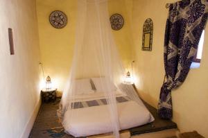 阿格兹达尔索法尔旅馆的一间卧室配有一张带蚊帐的床