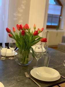 鲁斯特Casa Catalina的桌子上带眼镜的红花瓶