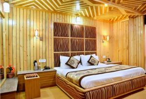 西姆拉Hotel Chaman Palace的一间卧室设有一张床和木墙