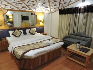 西姆拉Hotel Chaman Palace的配有一张床和一把椅子的酒店客房