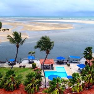 吉尼帕布多苏别墅客栈的享有棕榈树和蓝伞海滩的空中景致