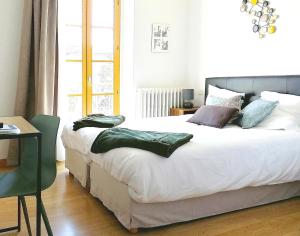 Beaufort-sur-GervanneHOTEL DU MIDI的卧室配有一张带枕头的大型白色床。