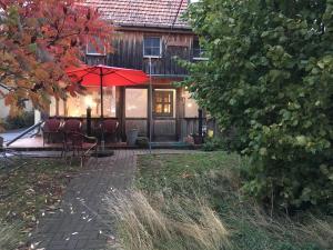 KleinzadelPension Elbkiosk的房屋设有带椅子和遮阳伞的庭院