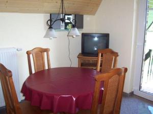 博尔滕哈根Zur-alten-Schmiede-II (Wohnung oben)的餐桌、椅子和电视