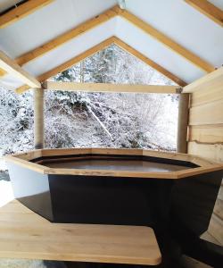 米日吉里亚Lisnyi的木制客房设有一个浴缸,配有窗户