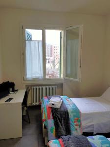 佐拉普雷多萨Braschi 8 B&B的酒店客房设有两张床、一张书桌和一个窗户。