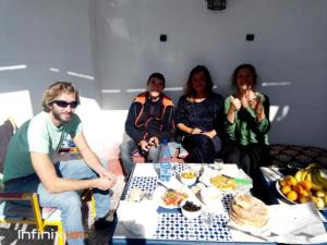 索维拉蓝白旅舍的一群人坐在桌子旁吃着食物