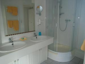 腓特烈斯科格Hotel Möven-Kieker的白色的浴室设有2个盥洗盆和淋浴。