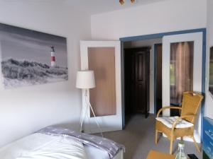 腓特烈斯科格Hotel Möven-Kieker的卧室配有一张床,墙上挂着灯塔照片