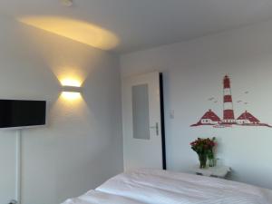 腓特烈斯科格Hotel Möven-Kieker的卧室配有一张床,墙上有灯