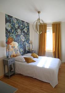 Villette-dʼAnthonMaison d'hôtes La Bella Casa的卧室配有一张大床,墙上挂有绘画作品