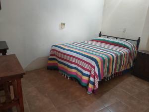 埃斯孔迪多港Hotel Posada Playa Manzanillo的一张床上的房间,上面有五颜六色的毯子
