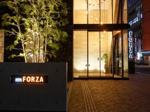 福冈HOTEL FORZA HAKATA-GUCHI的夜间在建筑物前的广场标志